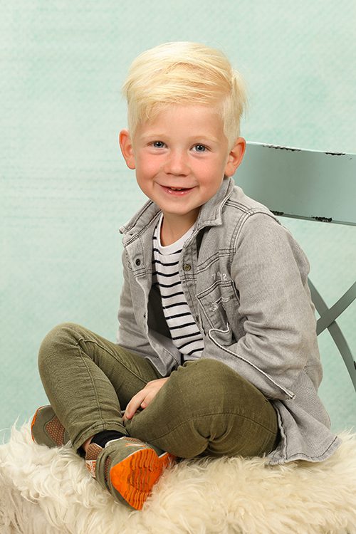 fotografie schoolfotografie jongen stoel glimlach